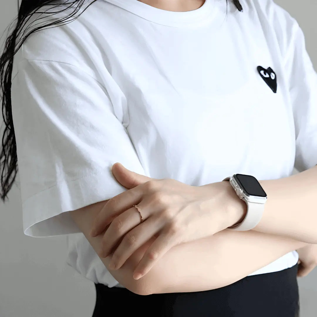 Alliance asymétrique en acier doré et oxydes de zirconium portée au doigt d'une femme vue de loin.