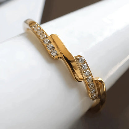 Alliance asymétrique en acier doré et oxydes de zirconium porté par un cône.