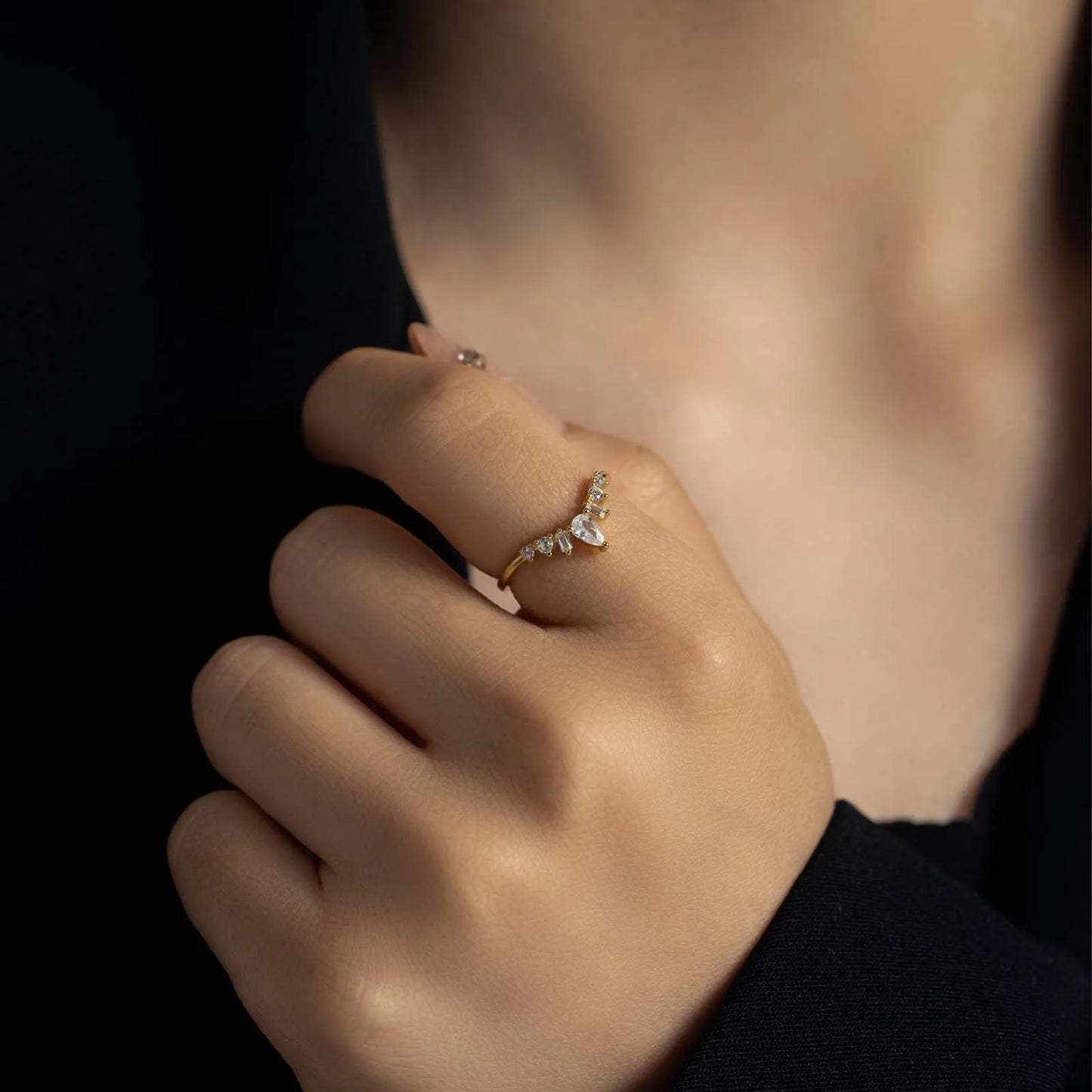 Alliance chevron en or jaune et diamants naturels portée au doigt d'une femme.