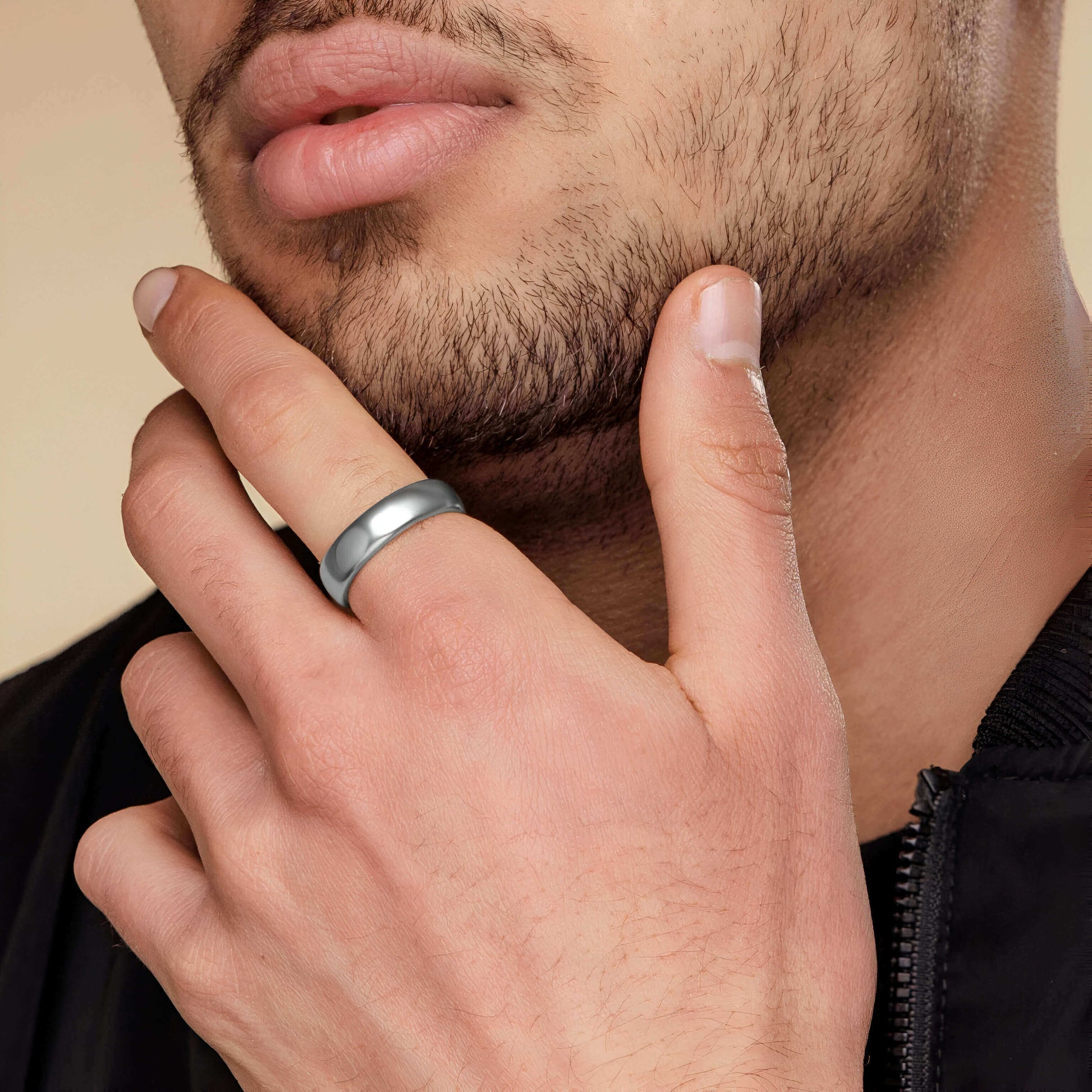 Alliance classique de mariage en acier inoxydable blanc portée au doigt d'un homme.