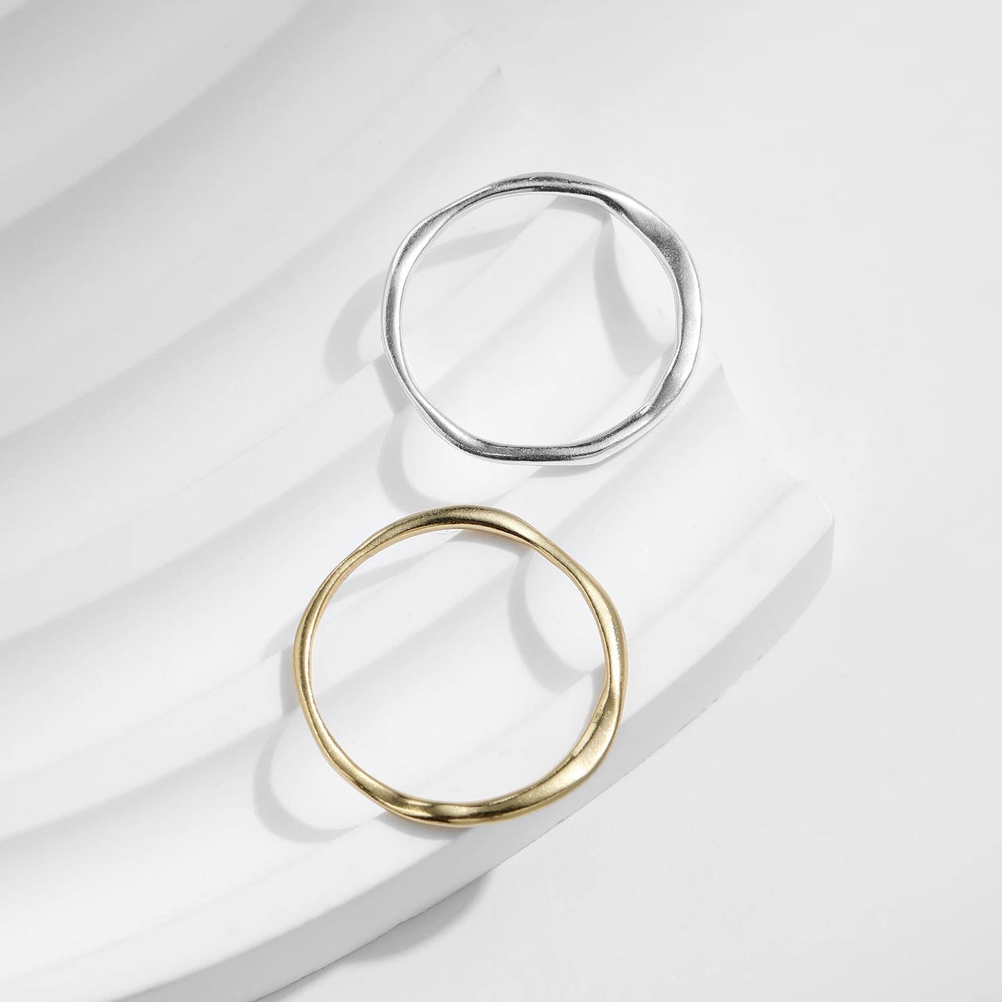 Alliances courbées en or jaune et or blanc à plat.