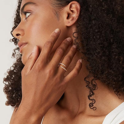 Alliance croisée Beliora en argent 925 plaqué or jaune et diamants portée au doigt d'une femme vue de loin.
