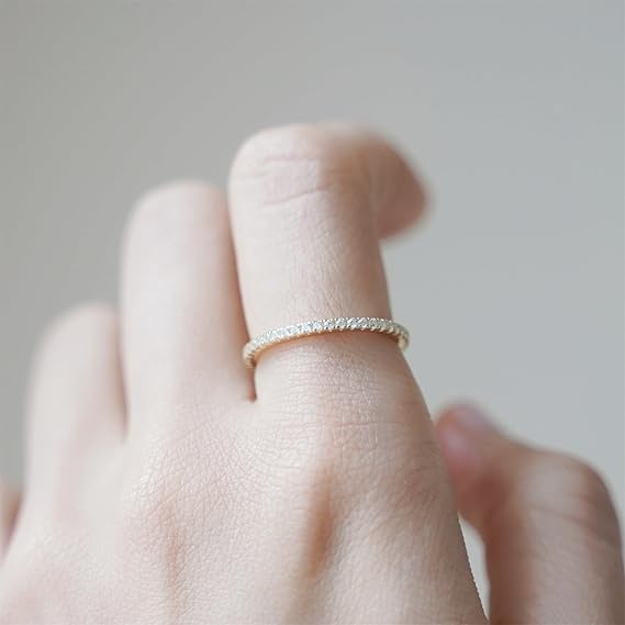 Alliance d'éternité fine calyra en argent 925 plaqué or jaune et diamants portée au doigt vue de proche.