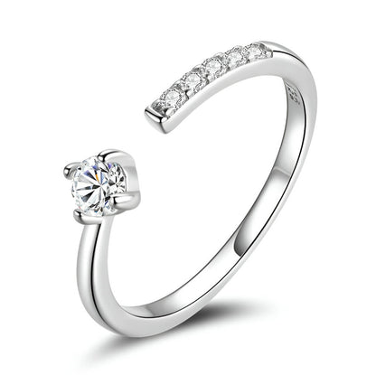 Alliance de mariage ouverte halomira en argent 925 plaqué or blanc délicat et diamants sur fond blanc.