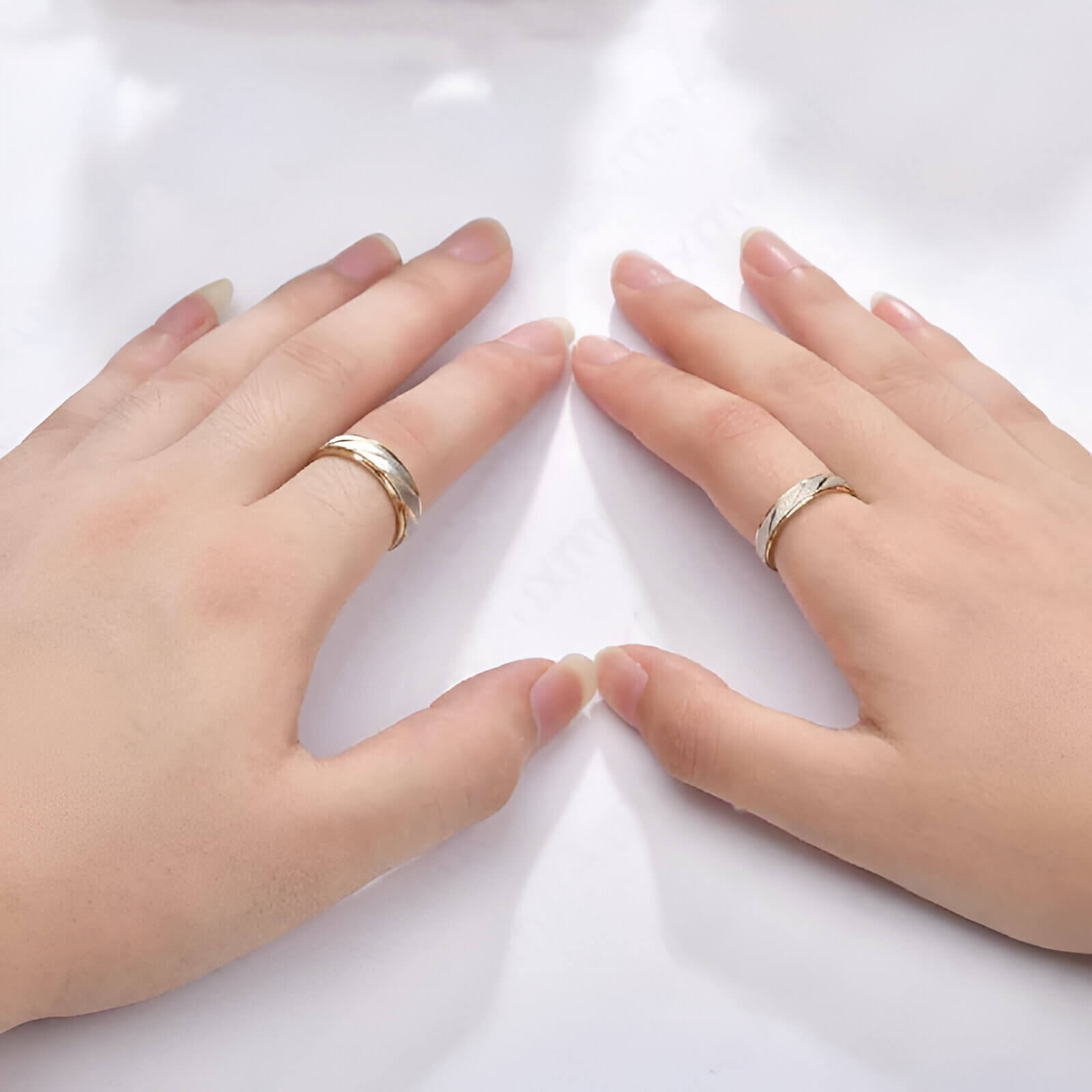 Variantes 4mm et 6mm de l'alliance de mariage ruban blanc rayé Hélios en acier 316L plaqué or jaune 14K portées aux doigts d'une femme.