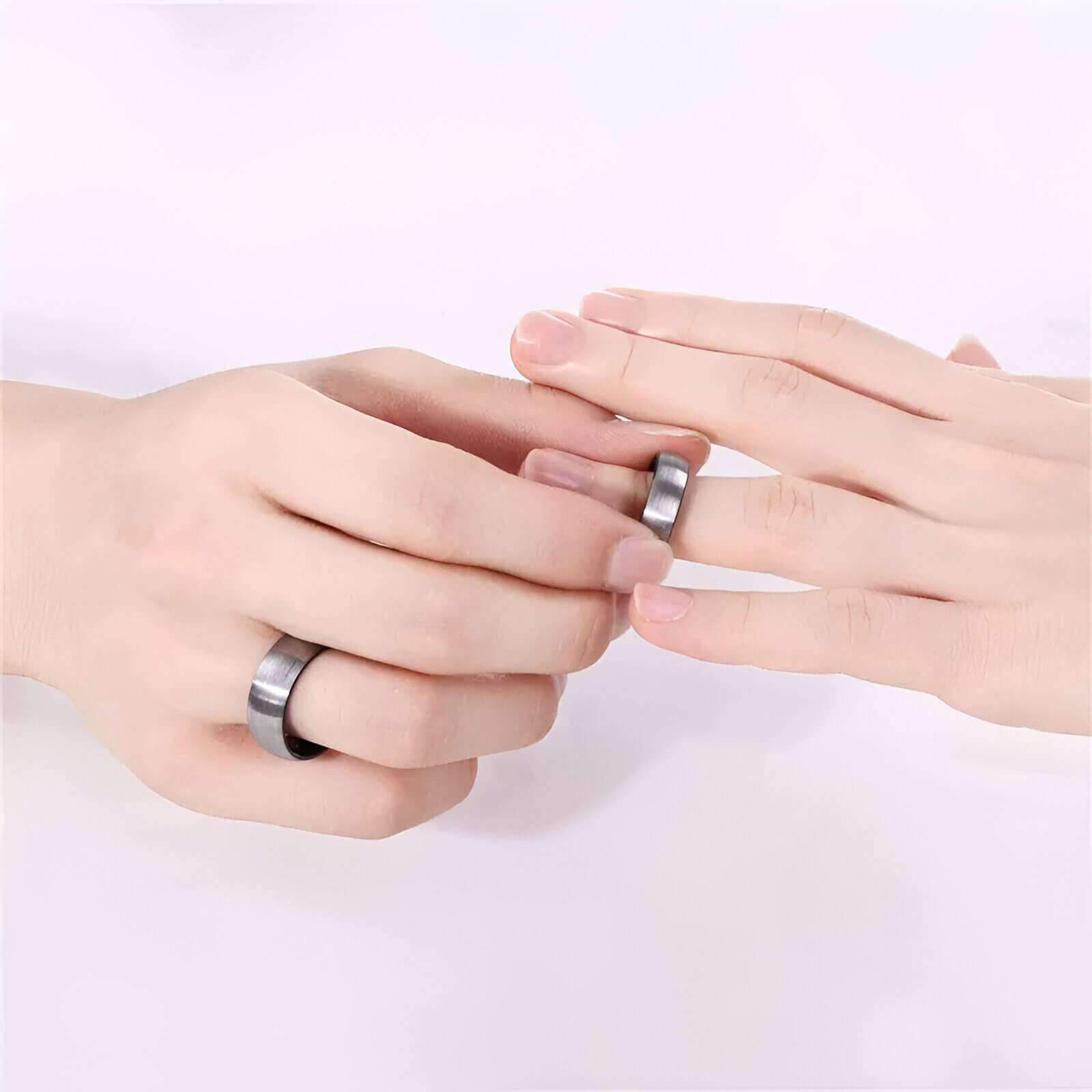 Alliance demi-jonc en tungstène blanc de 6 mm et 8 mm portées aux doigt d'un homme et d'une femme.