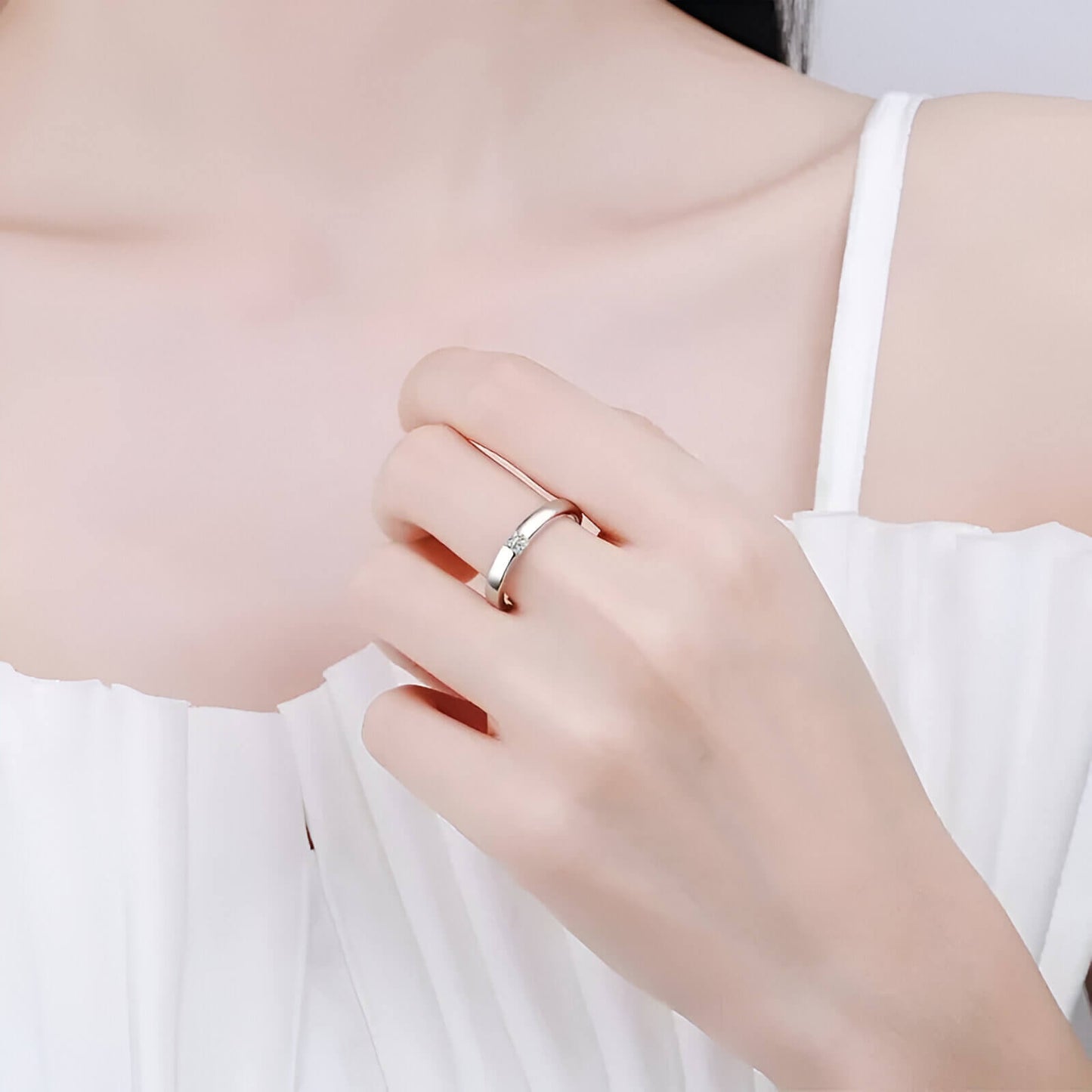 Alliance diamant princesse serti clos Andréa en argent 925 plaqué or blanc  discret portée au doigt d'une femme vue de face.