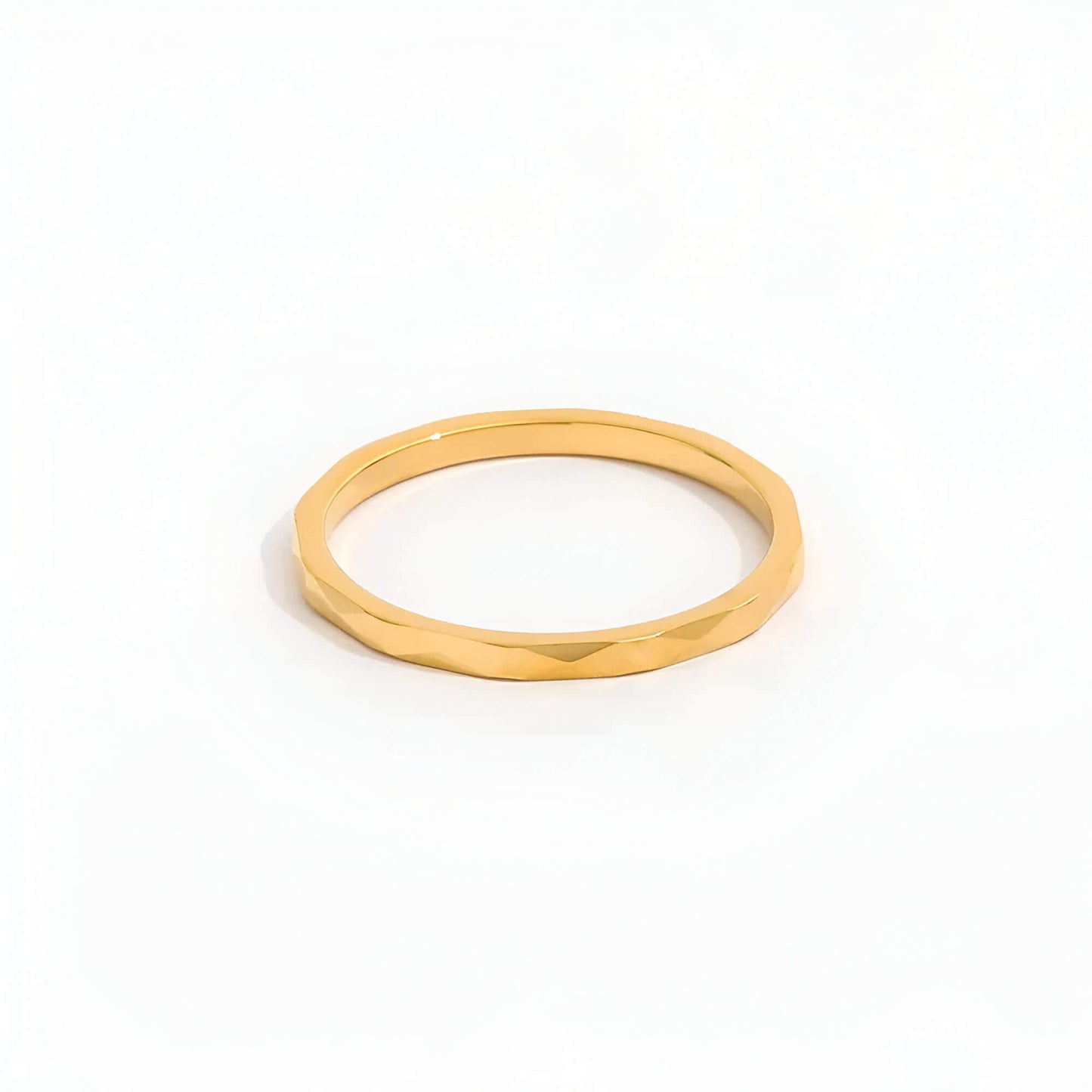 Alliance discrète multi-facettes dorées Noa en acier plaqué or jaune 14K sur fond blanc.