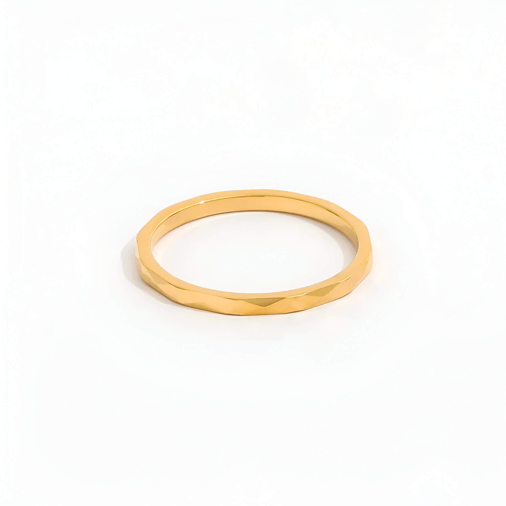 Alliance discrète multi-facettes dorées Noa en acier plaqué or jaune 14K sur fond blanc.