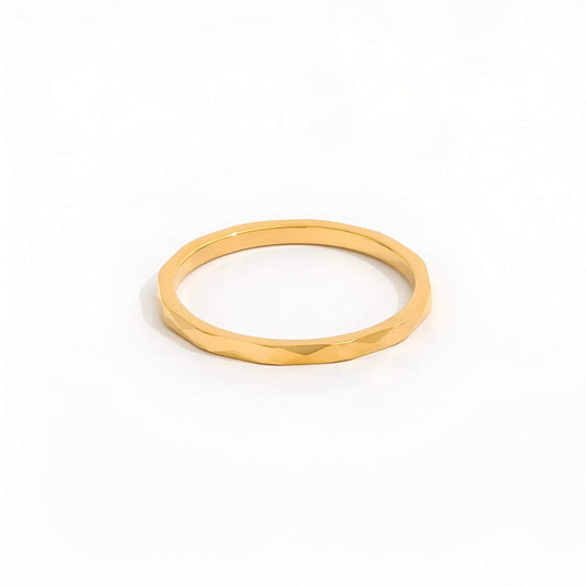 Alliance discrète multi-facettes dorées Noa en acier plaqué or jaune 14K sur fond blanc.