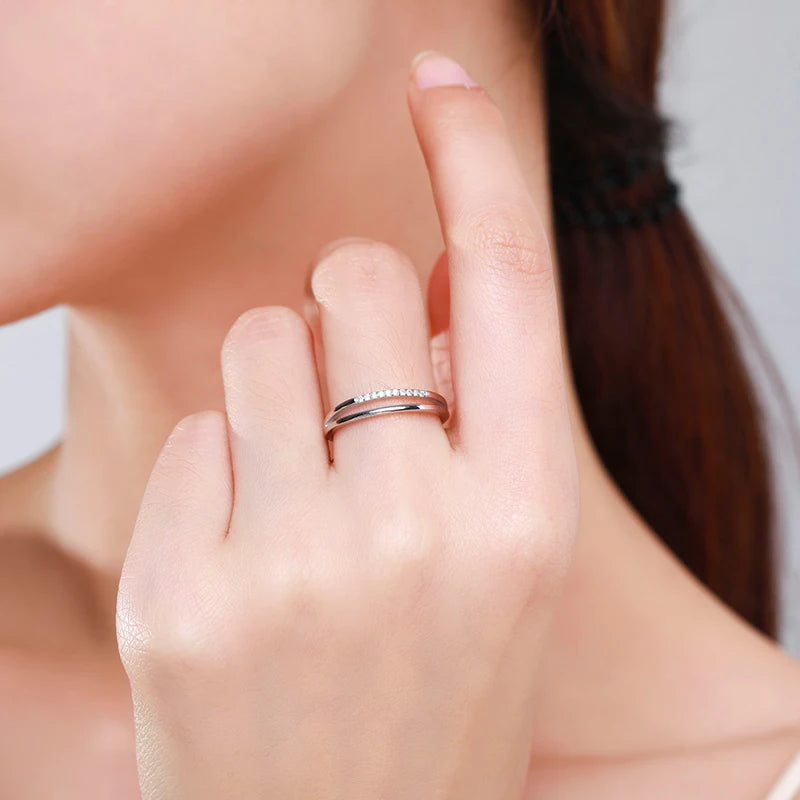 Alliance entaille fine Novae en argent 925 plaqué or blanc et diamants étincelants portée au doigt d'une femme vue de proche.