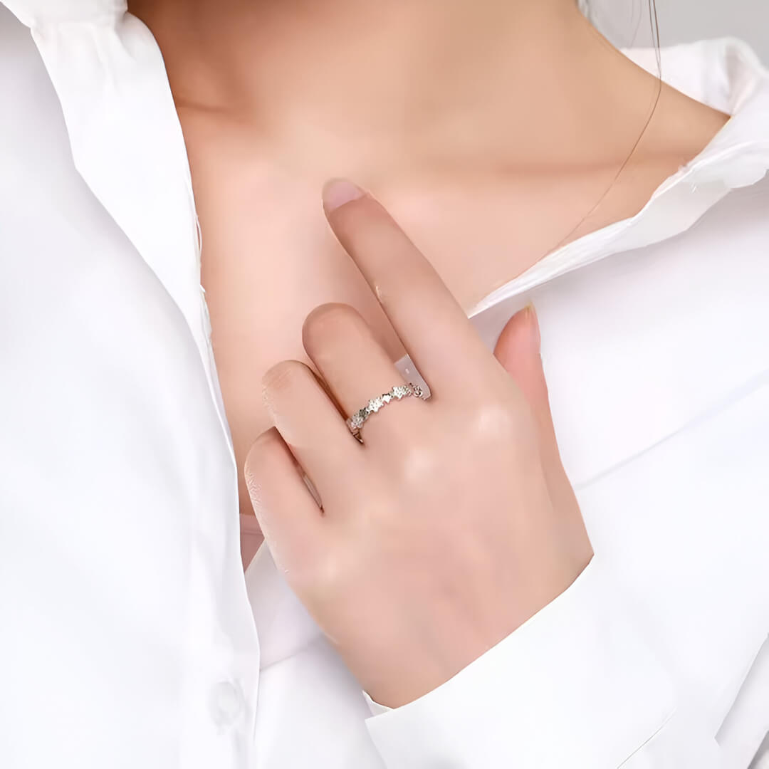 Alliance étoile en argent rhodié et or blanc sertie de diamants naturels portée au doigt d'une femme.