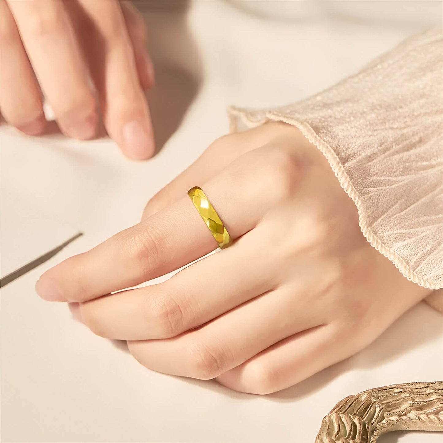 Alliance facettée de 6mm en tungstène et or jaune portée au doigt d'une femme.