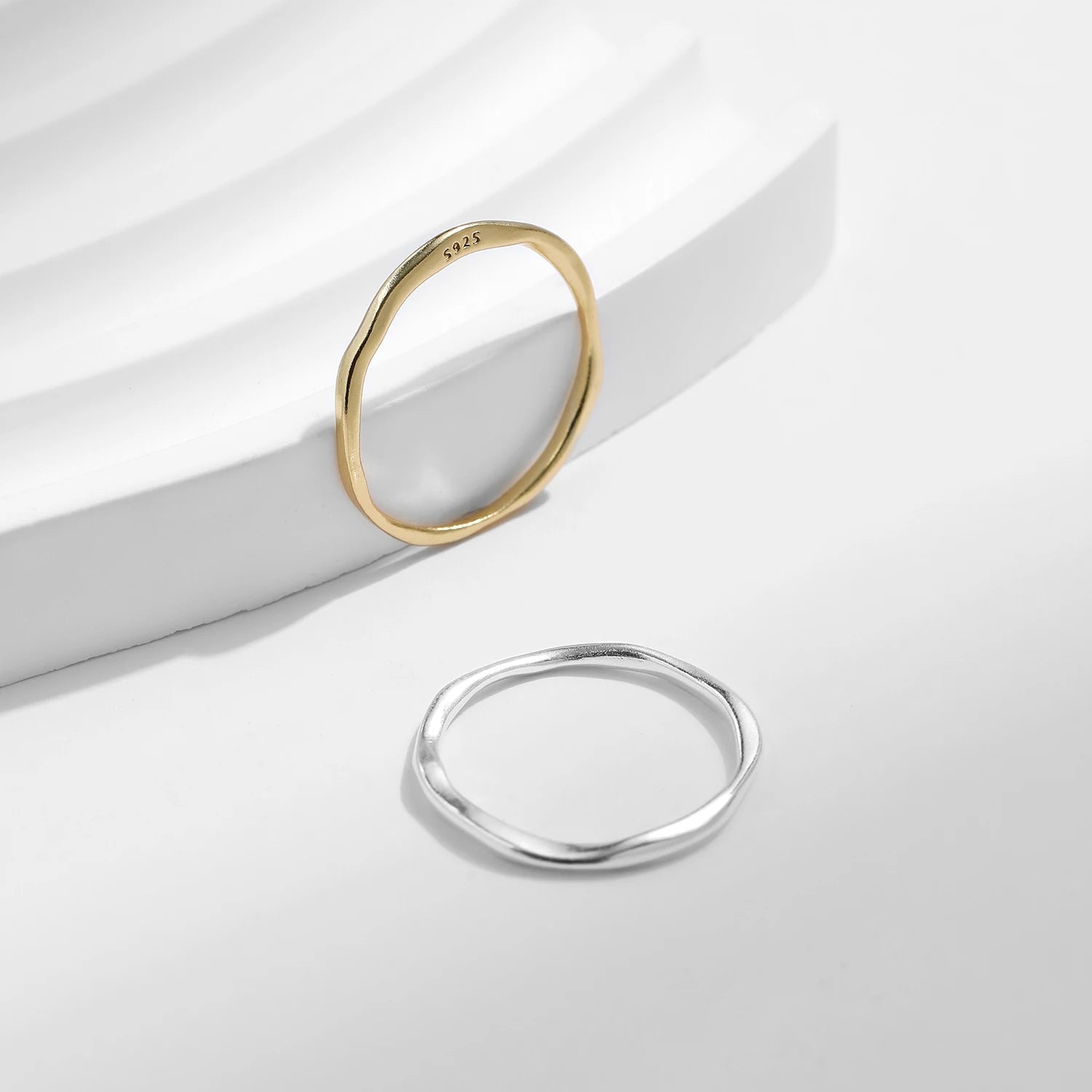 Variantes de l'alliance fine courbée Fenrya en argent sterling 925 plaqué or jaune ou plaqué or blanc posées.