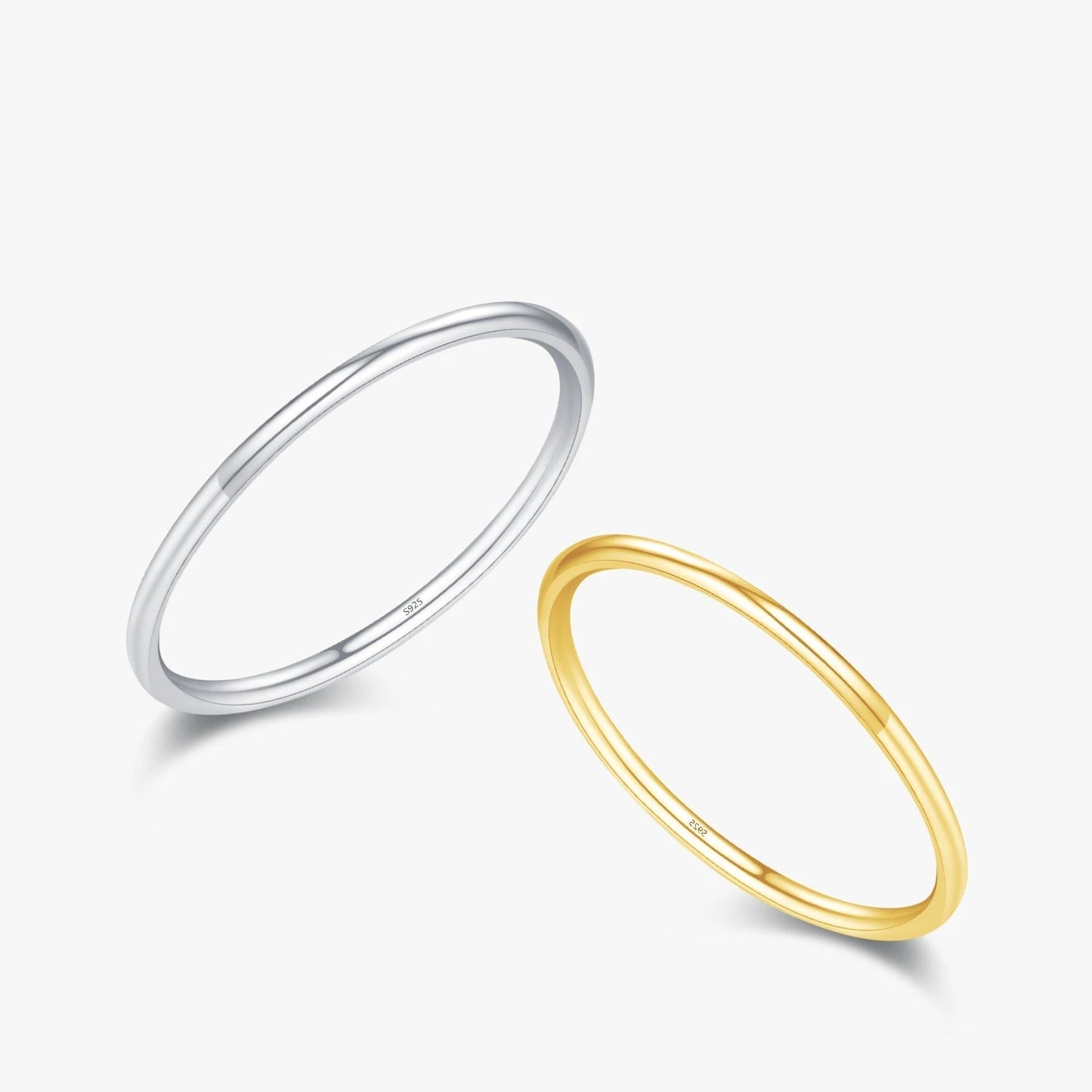 Alliances fines en or jaune et or blanc sur fond blanc.