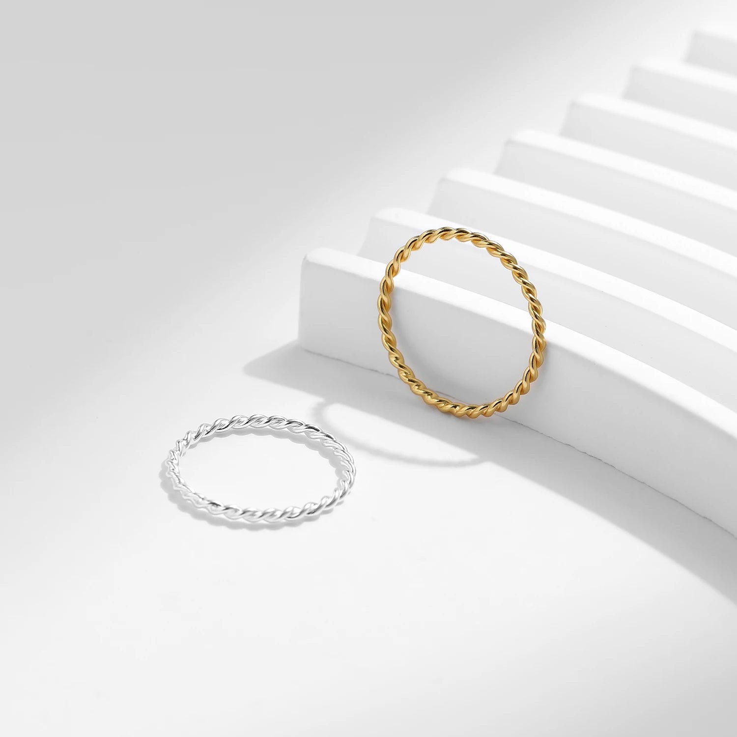 Variantes de l'alliance fine twistée Evelisya en argent sterling 925 plaqué or jaune ou plaqué or blanc posées.