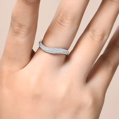 Alliance incurvée pavée de diamants éclatants en argent 925 plaqué or blanc portée au doigt d'une femme vue de proche.