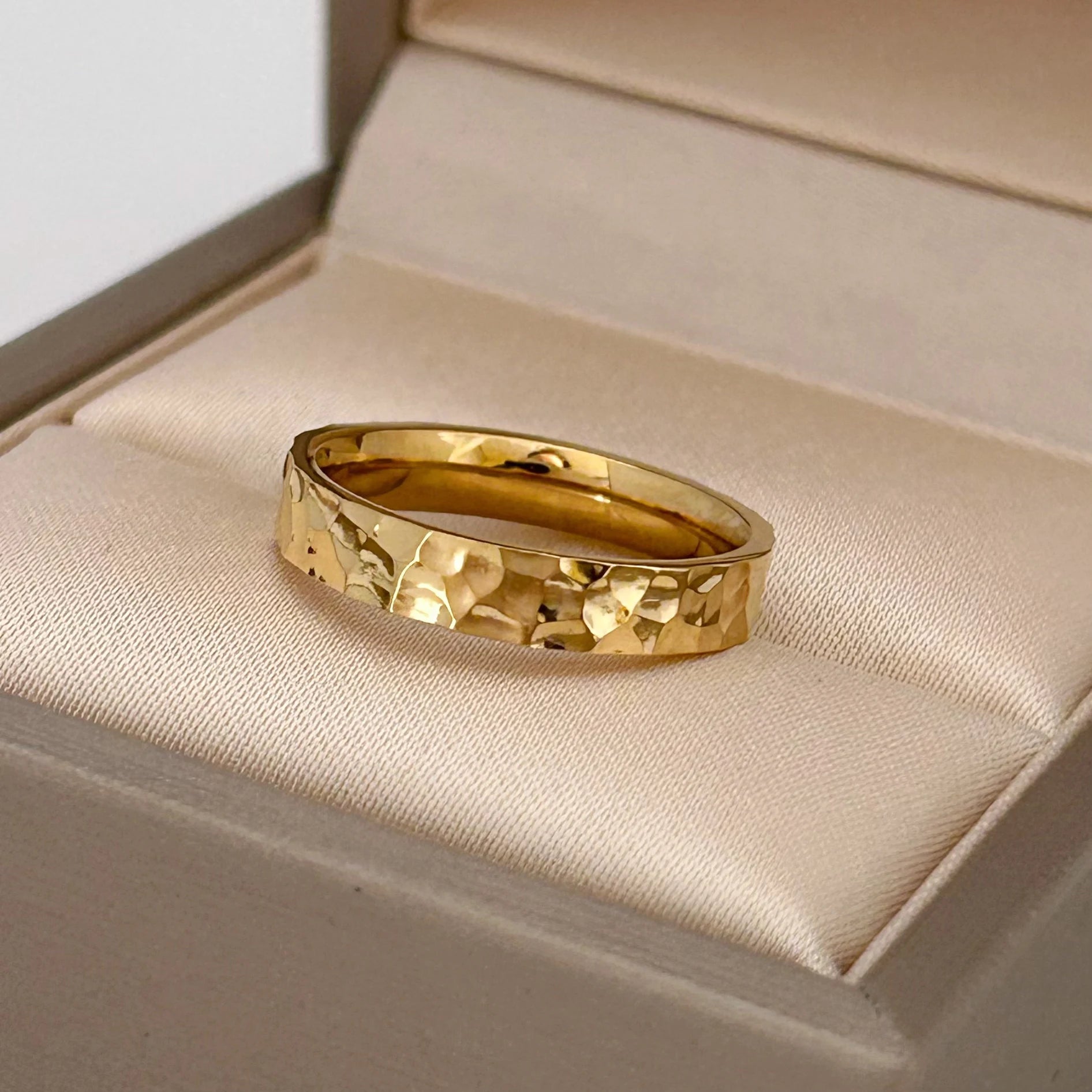 Alliance martelée style unique Lumeris en acier inoxydable 316L plaqué or jaune 18K raffiné posée dans son écrin.