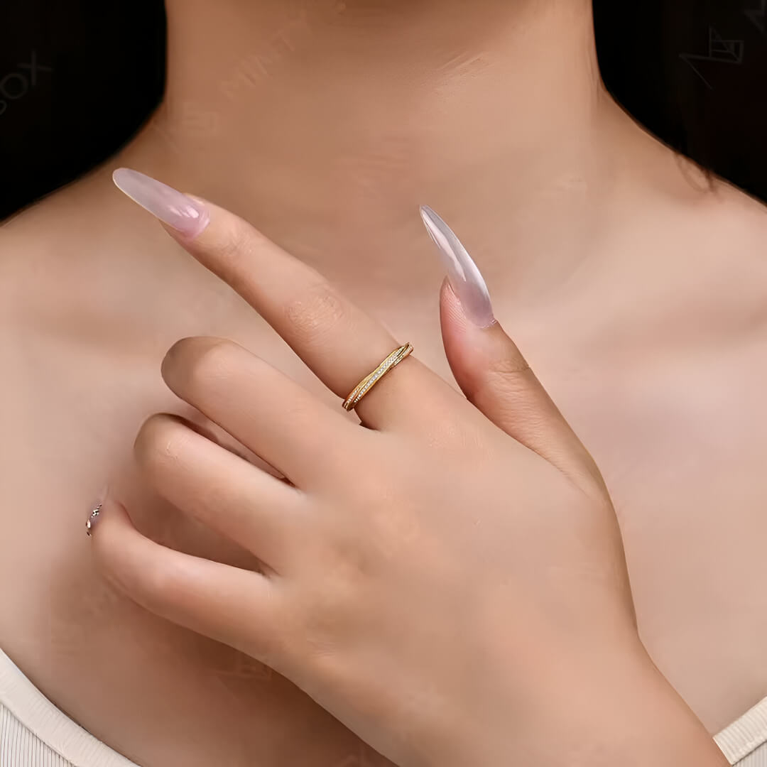Alliance mobius en or jaune et diamant synthétique portée au doigt d'une femme vue de loin.