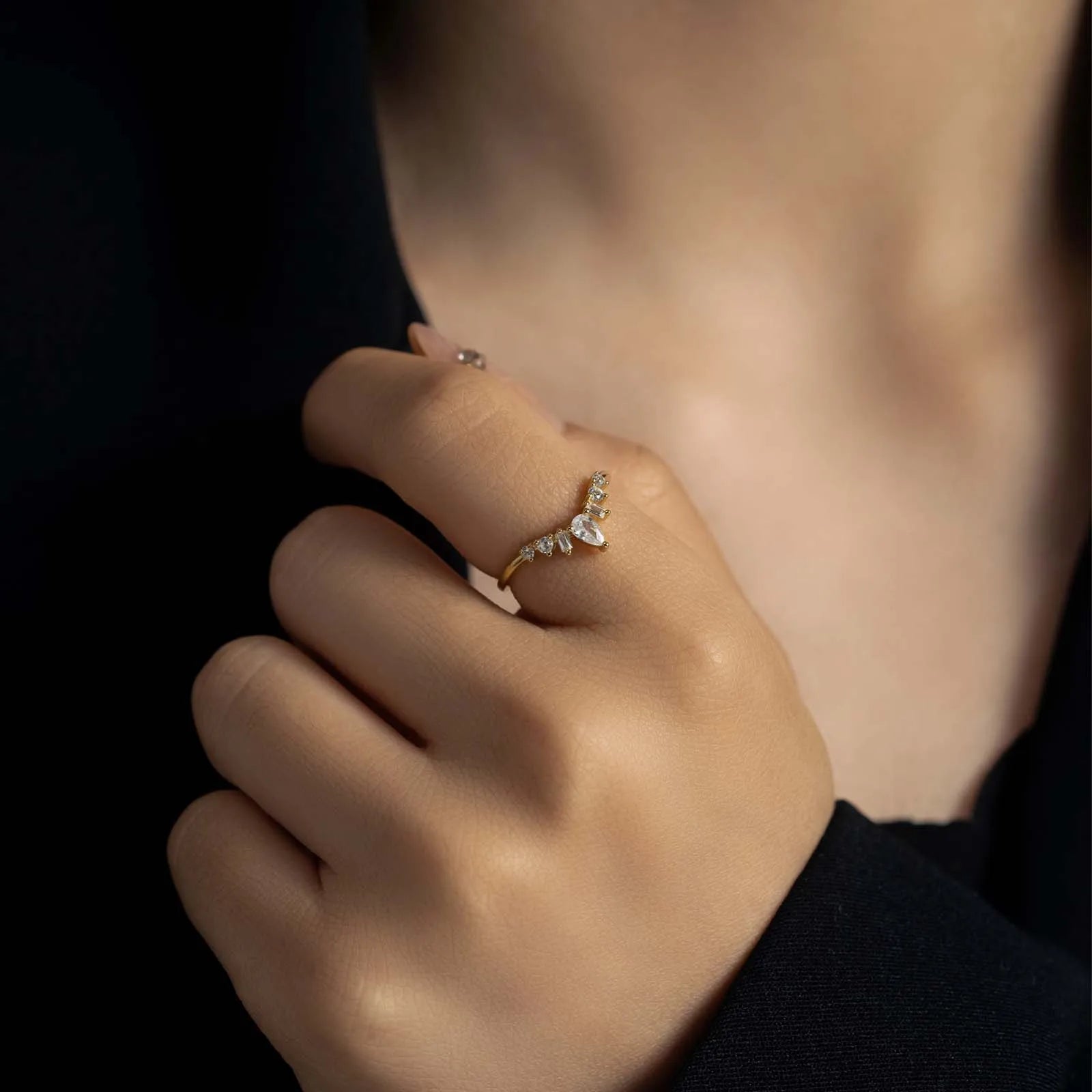 Main de femme portant au doigt une alliance chevron de diamants variante or jaune.