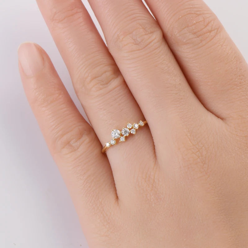 Main de femme portant au doigt une alliance pavage de diamants en or jaune.