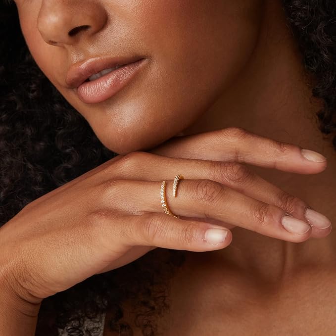 Alliance ouverte croisée en or jaune et diamants naturels portée au doigt d'une femme vue rapprochée.