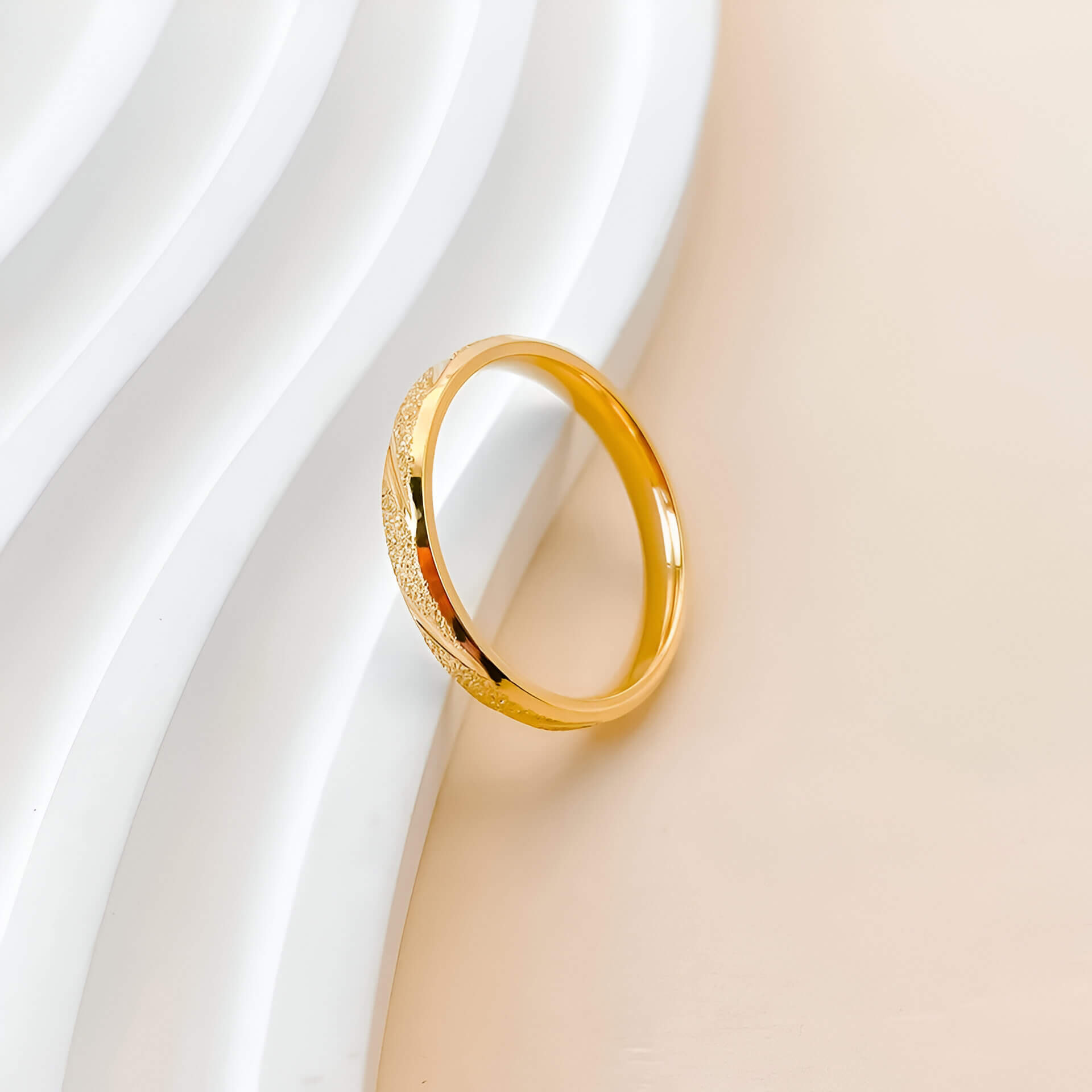 Alliance rayée en acier inoxydable et or jaune posée.