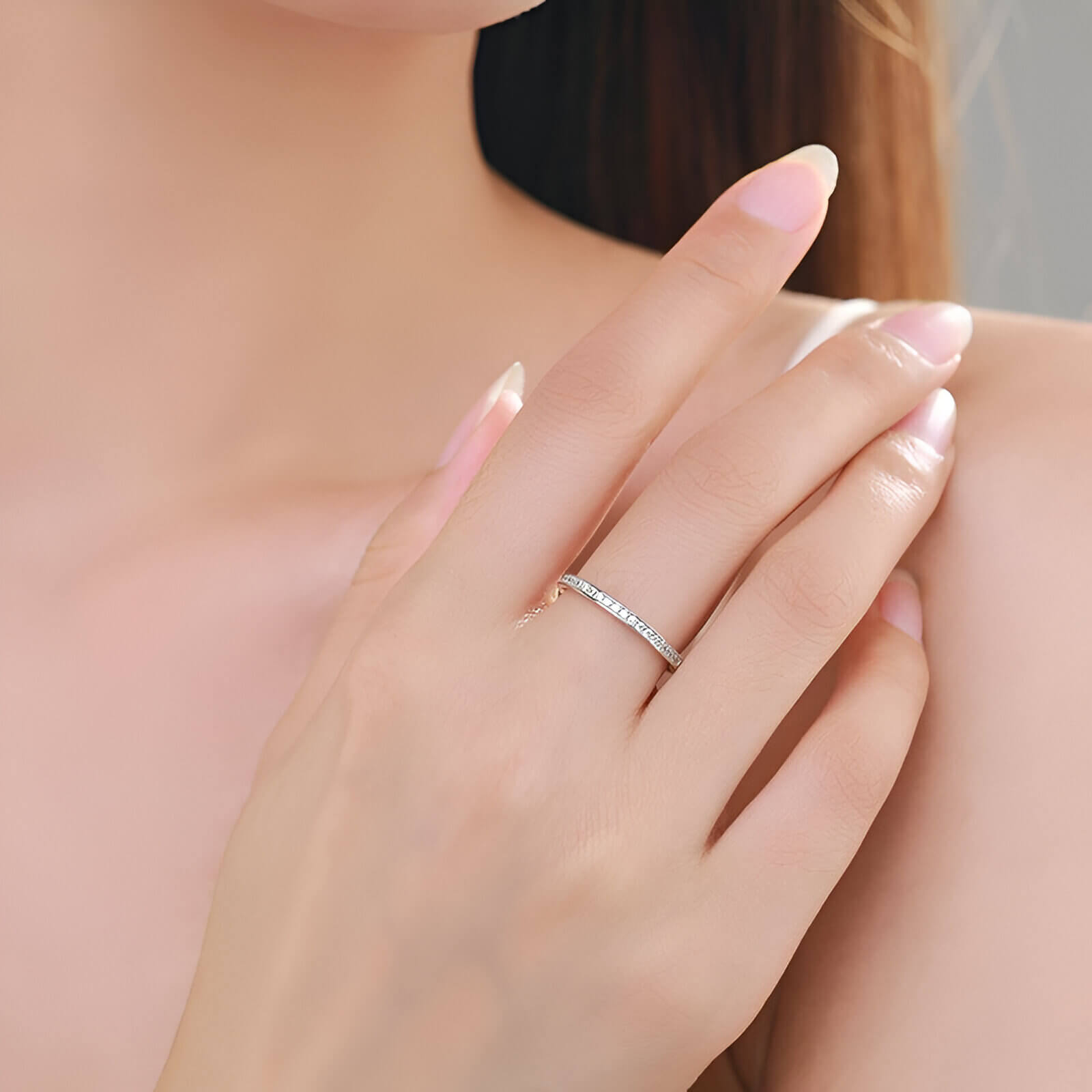 Alliance semi-éternité en or blanc et rhodium sertie de diamants naturels portée au doigt d'une femme.