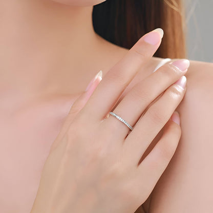 Alliance semi-éternité en or blanc et rhodium sertie de diamants naturels portée au doigt d'une femme.