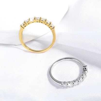 Alliances semi-éternité en or jaune et or blanc serties de diamants synthétiques sur une nappe blanche. 