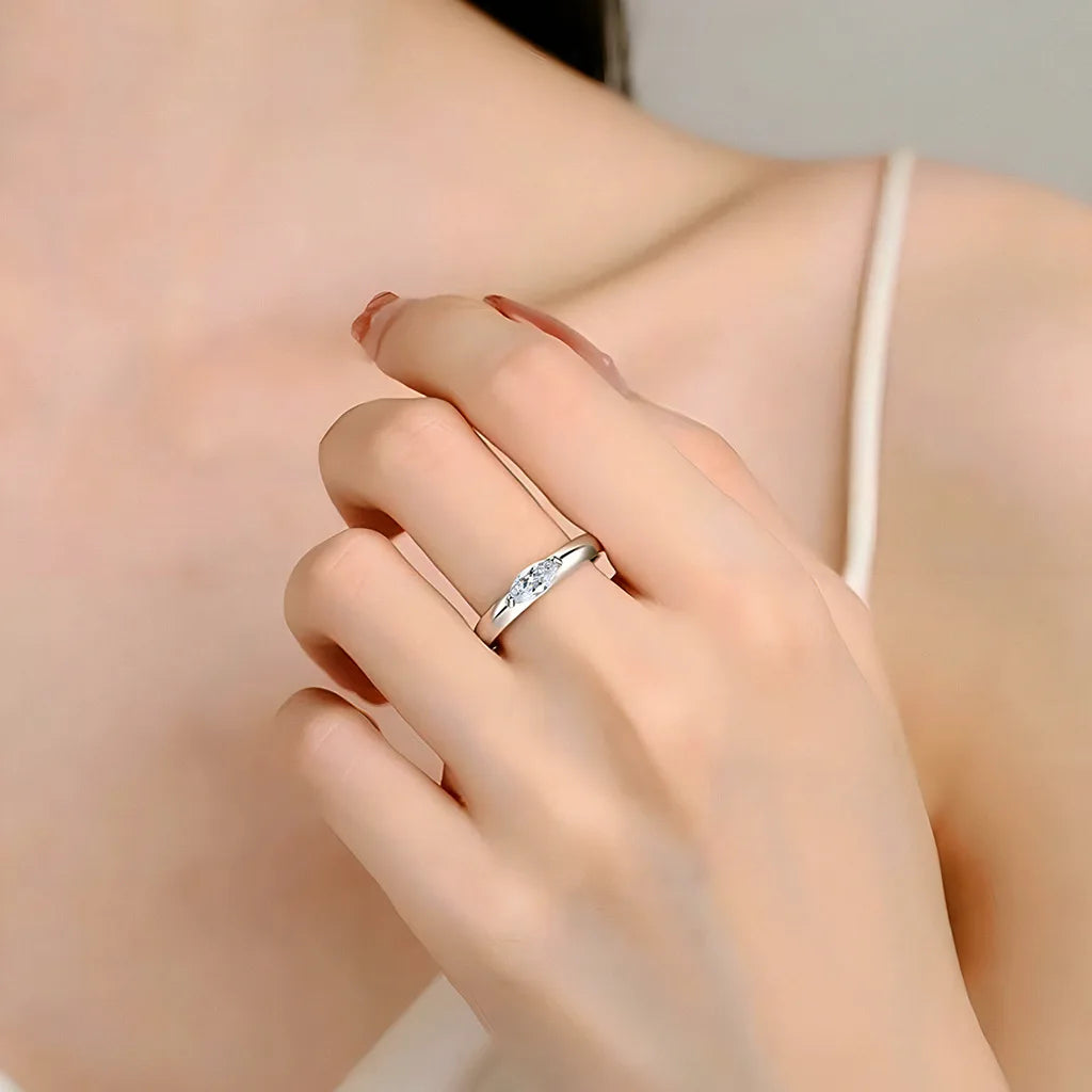 Alliance serti barre Shirin en platine plaqué or blanc et diamant navette éclatant portée au doigt d'une femme vue de face.