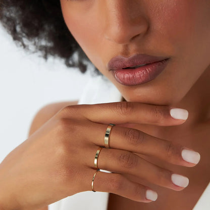 Alliance statement épaisse 3mm en argent 925 plaqué or jaune portée au doigt d'une femme vue de proche.