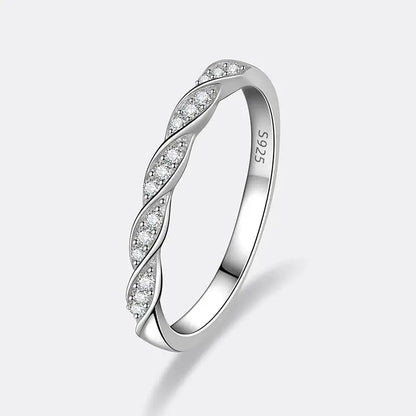 Alliance torsadée en or blanc et diamants synthétiques sur fond gris clair.