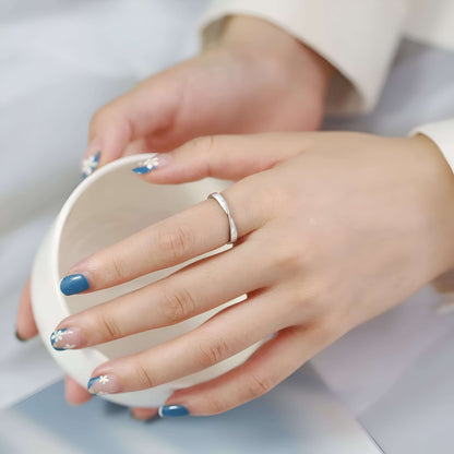 Alliance torsadée mobius en acier inoxydable et or blanc portée au doigt d'une femme.