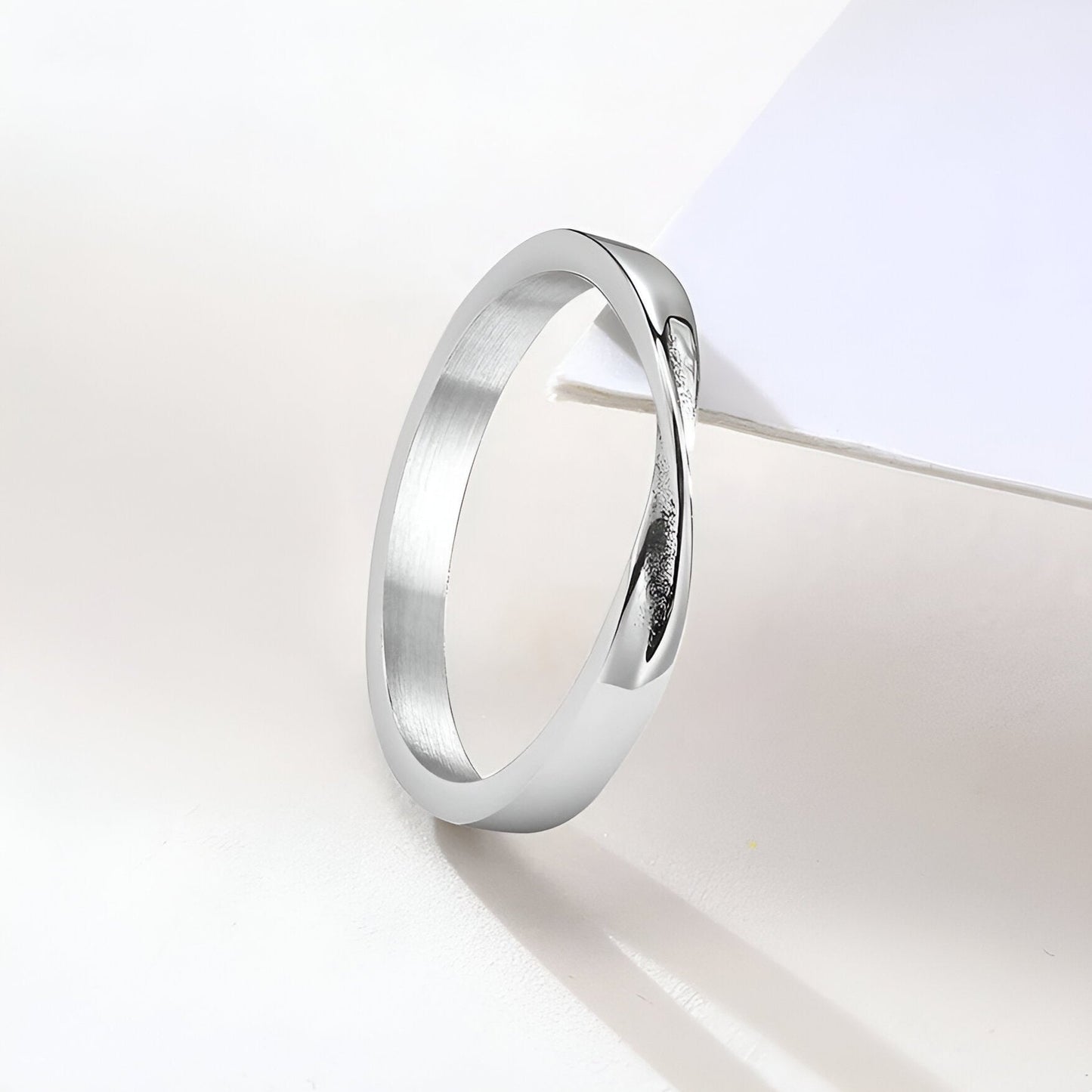 Alliance torsadée mobius en acier inoxydable et or blanc posée.