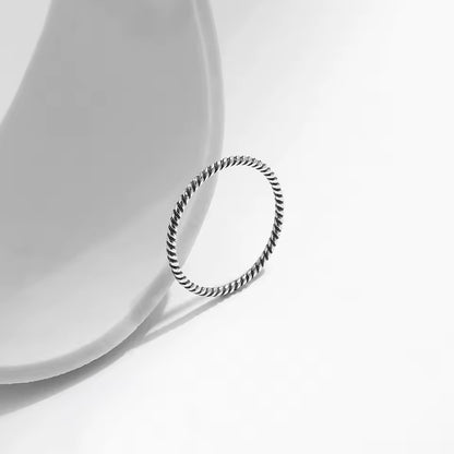 Alliance torsadée en argent 925 et rhodium debout.