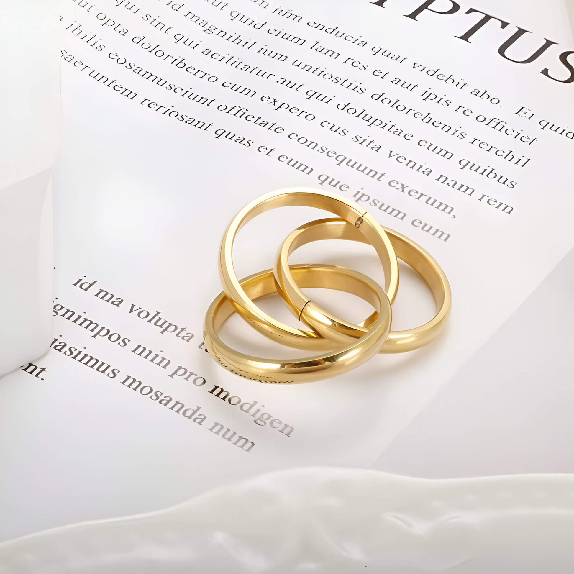 Alliance triple demi-jonc en acier plaqué or jaune posée.