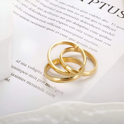 Alliance triple demi-jonc en acier plaqué or jaune posée.