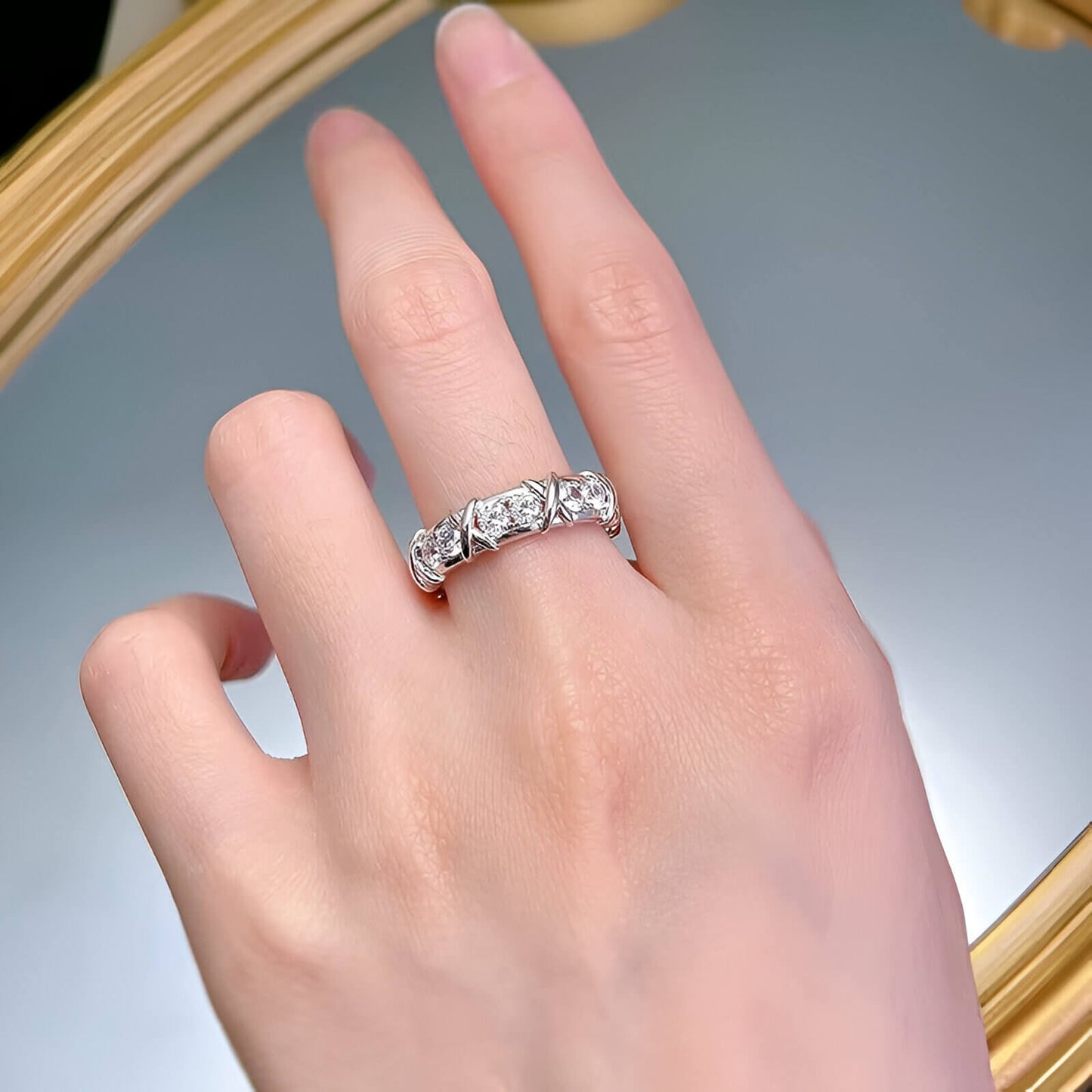 Alliance x en or blanc et diamant naturel portée au doigt d'une femme.