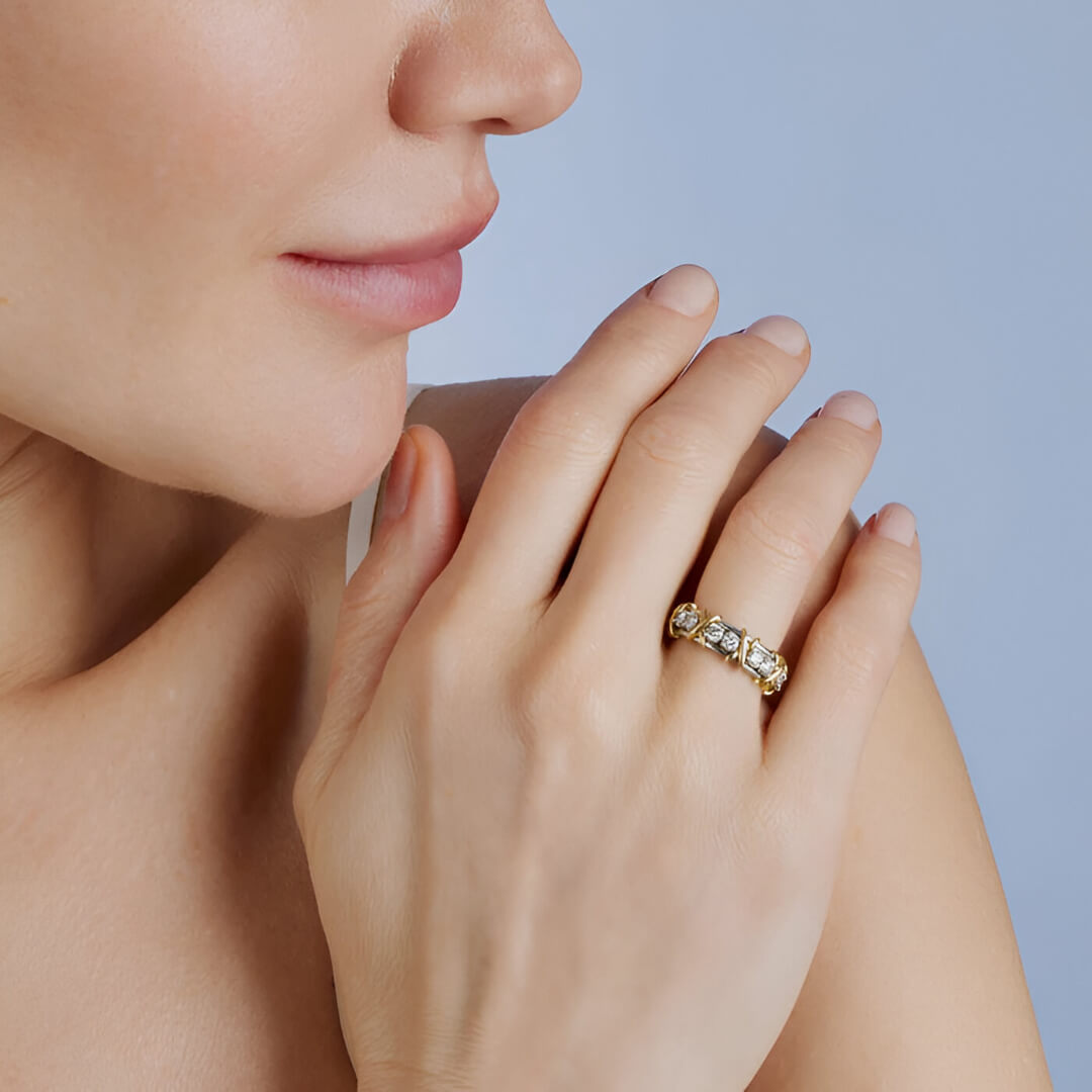 Alliance x en or jaune et diamant naturel portée à l'annulaire d'une femme.