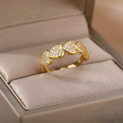 Bague ajustable cinq cœurs dorés sertis de petits diamants scintillants Hecate en acier 316L plaqué or jaune 18K rangée dans son écrin.