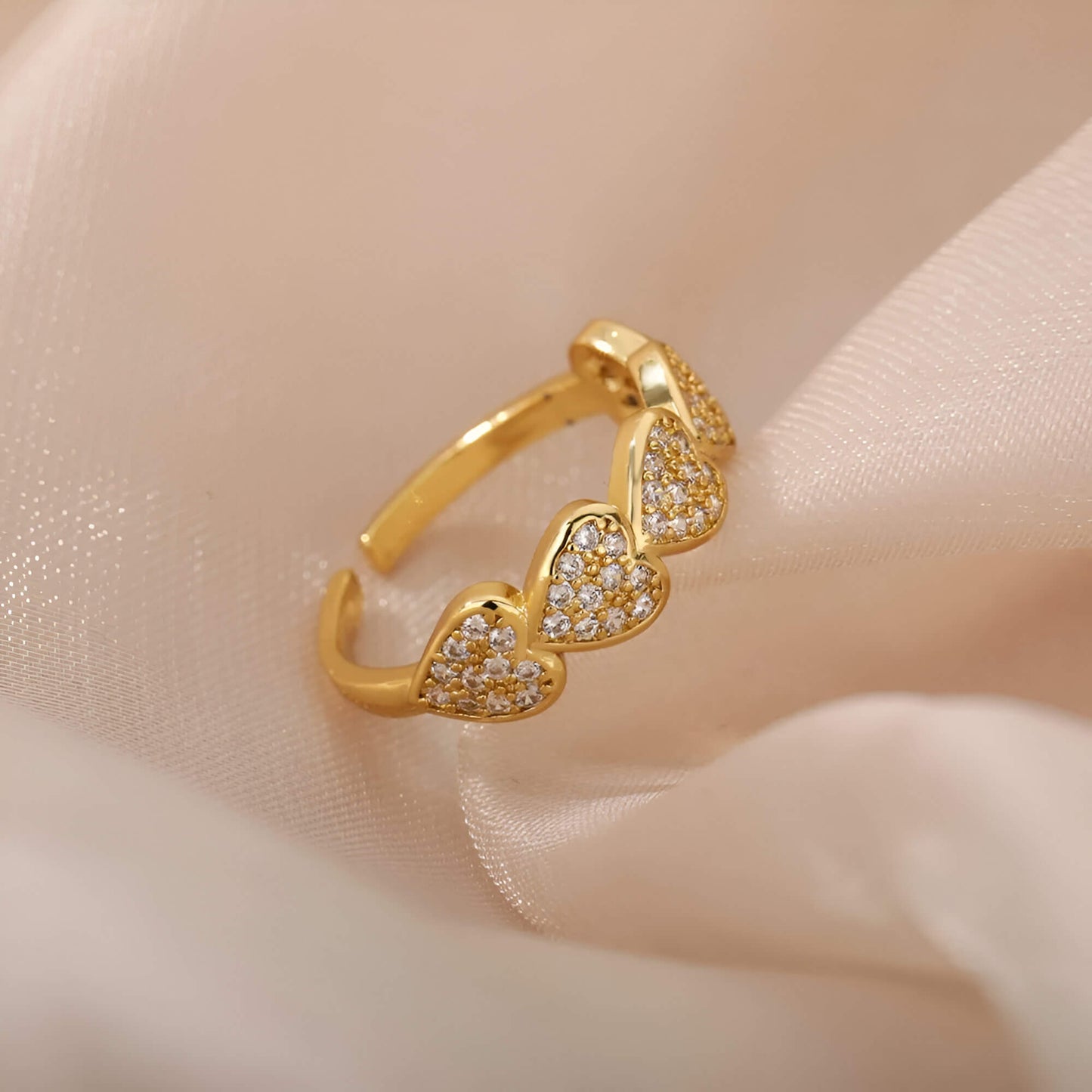 Bague ajustable cinq cœurs dorés sertis de petits diamants ronds Hecate en acier plaqué or jaune 18K posée.