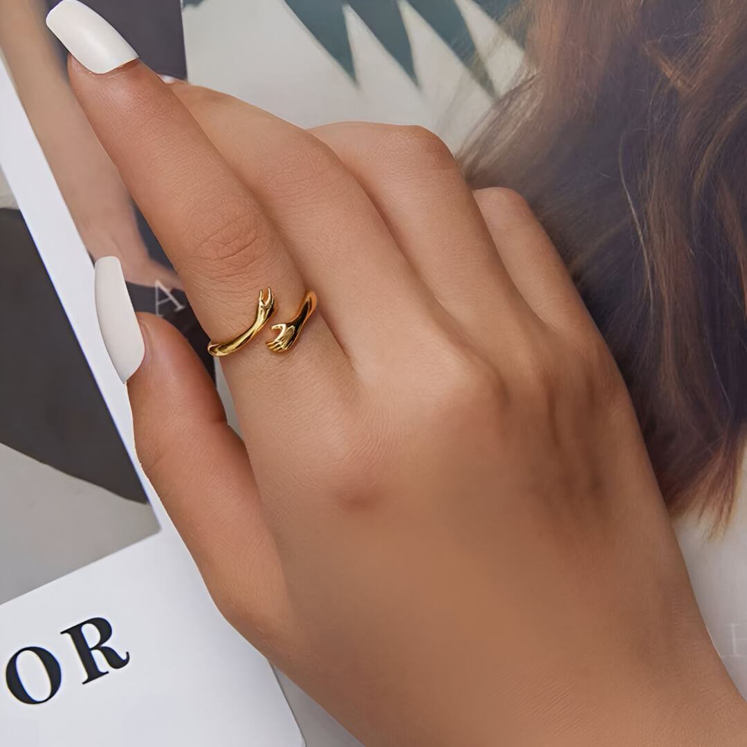 Bague ajustable main entrecroisée en argent 925 plaqué or jaune lumineux portée au doigt d'une femme vue du dessus.