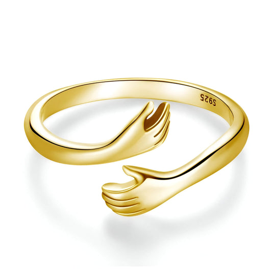 Bague ajustable main entrecroisée en argent 925 plaqué or jaune sur fond blanc.