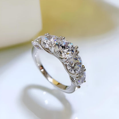 Bague de fiançailles cinq pierres en or blanc et diamants synthétiques debout.