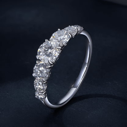 Bague cinq pierres graduées en or blanc et diamants synthétiques debout.