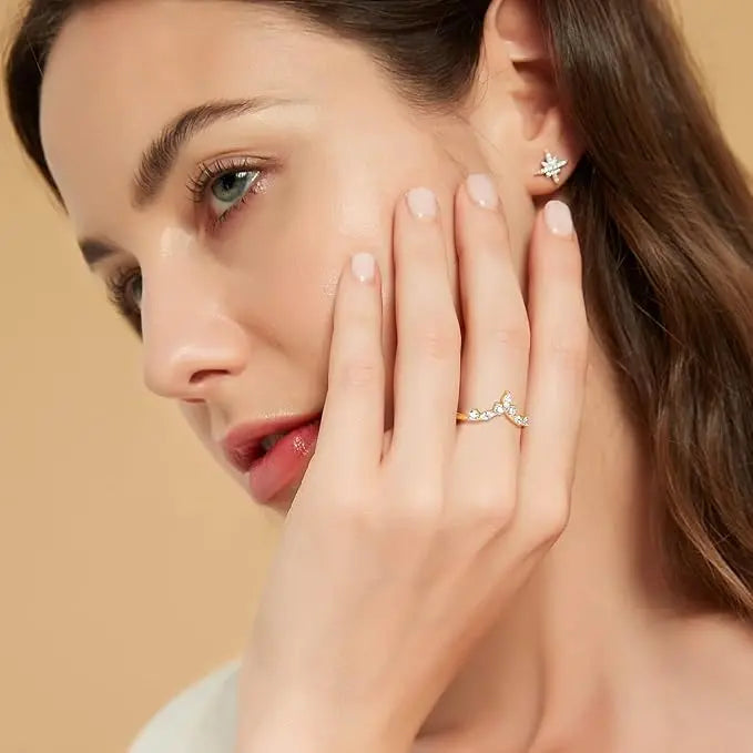 Bague courbée Serapine en acier inoxydable plaqué or jaune et sept diamants éclatants portée au doigt d'une femme vue de face.