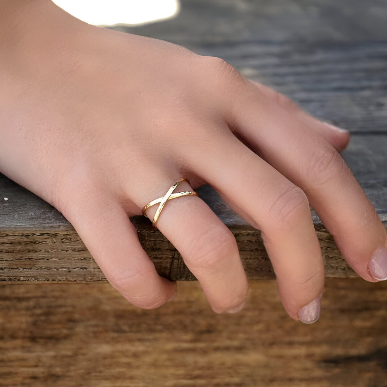 Bague croisement Nymiriel en argent sterling 925 plaqué or jaune portée au doigt d'une femme vue de proche.