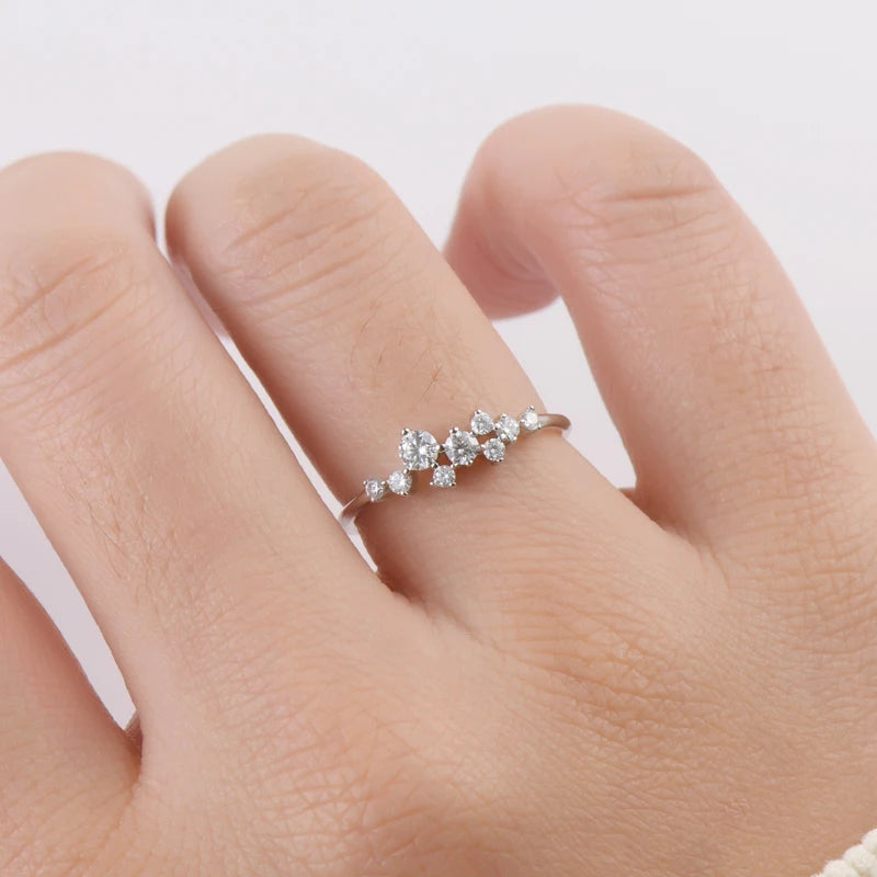 Bague d'engagement pavée Amarisse en argent 925 plaqué or blanc et diamants portée au doigt d'une femme vue de proche.