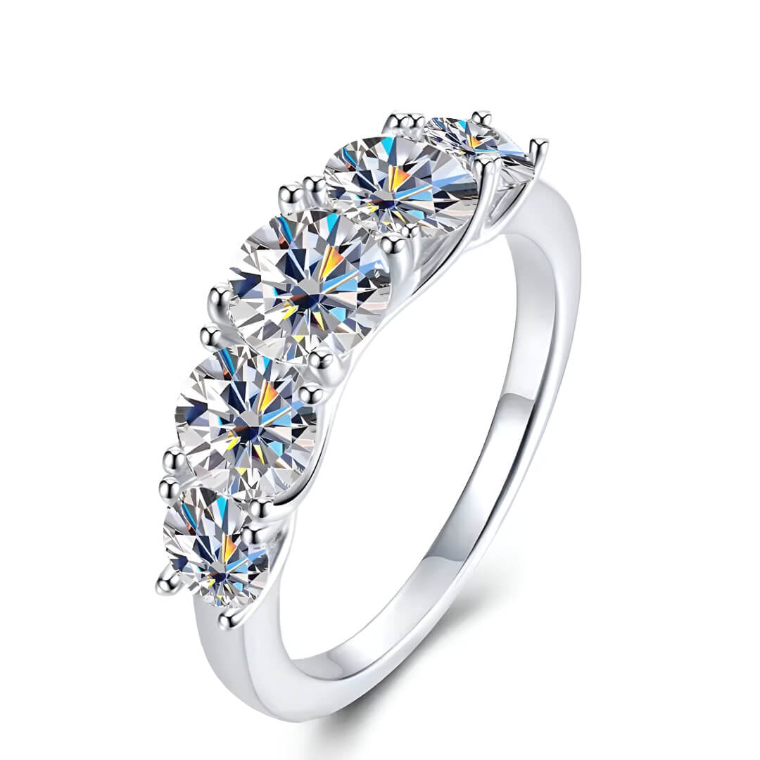 Bague de fiançailles cinq pierres en argent 925 plaqué or blanc et moissanites sur fond blanc.